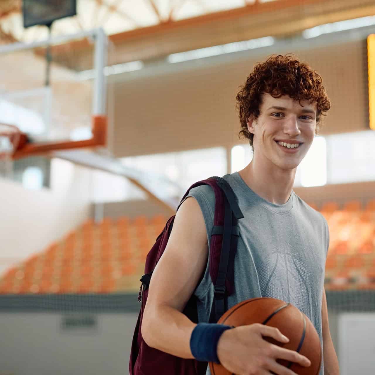 Student-athlete holding a basketball in a gym